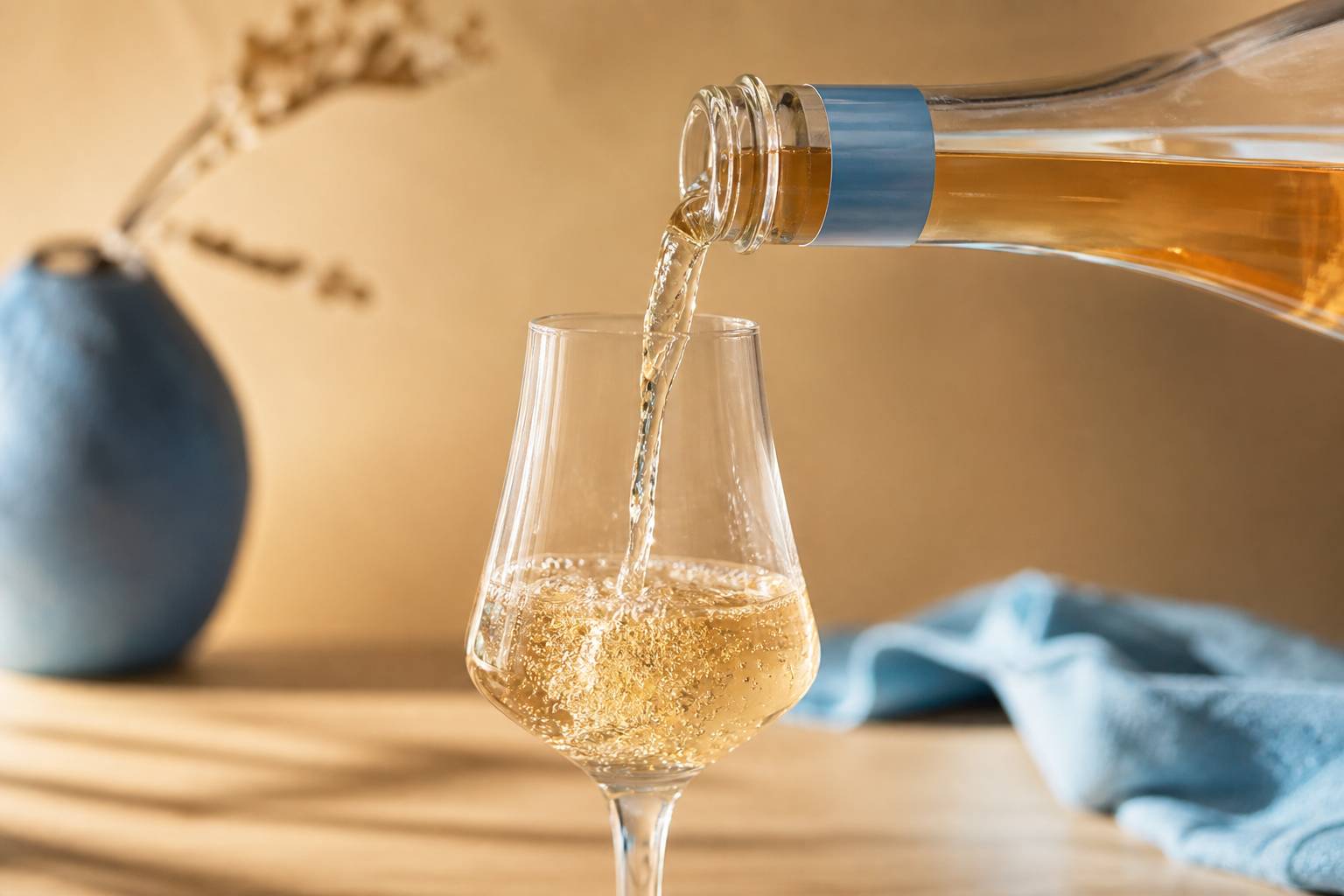 Bouteille de spiritueux sans alcool versée dans un verre tulipe avec bulles fines et élégance